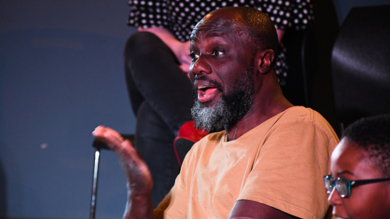 Man with his hand raised as part of an acting rehearsal