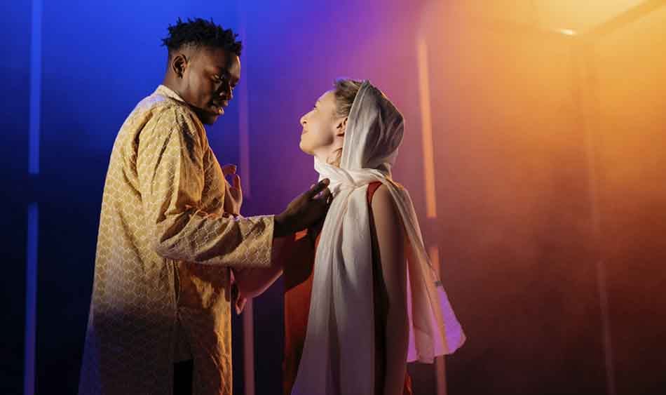 Victor Oshin (Othello) reaches towards Kitty Archer (Desdemona) as they look into each other's eyes. From ETT's Othello © Helen Murray.