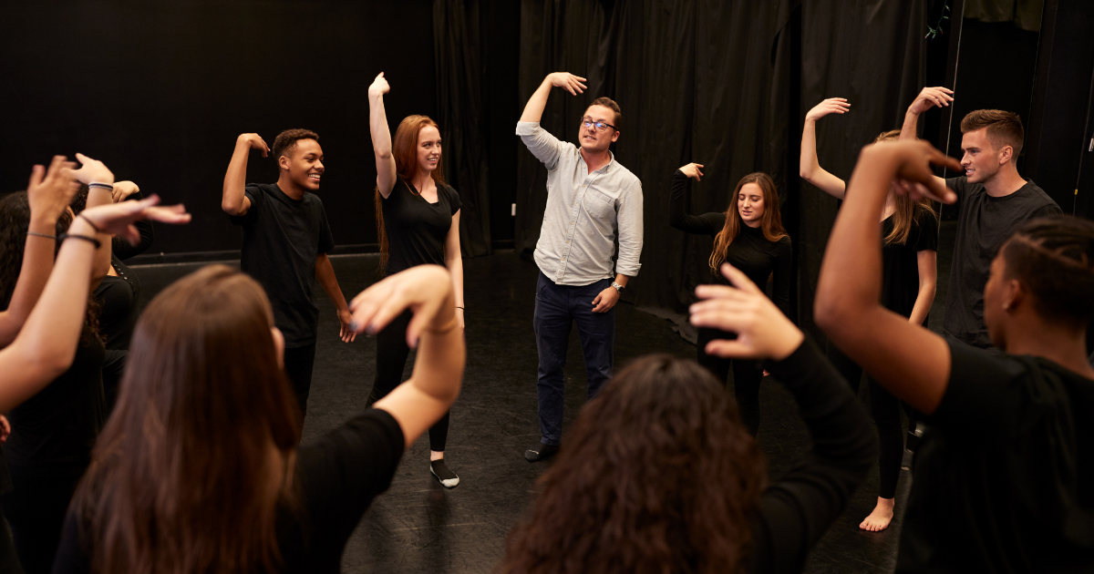 Students and teacher stand in a circle