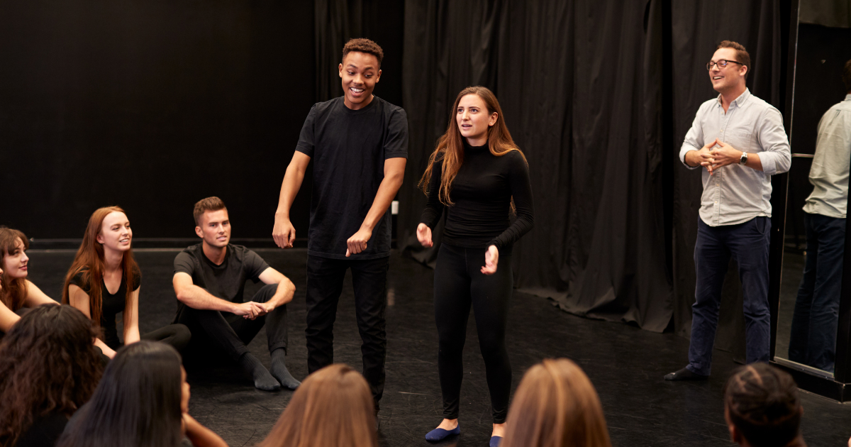 Students dressed in black participating in drama workshop