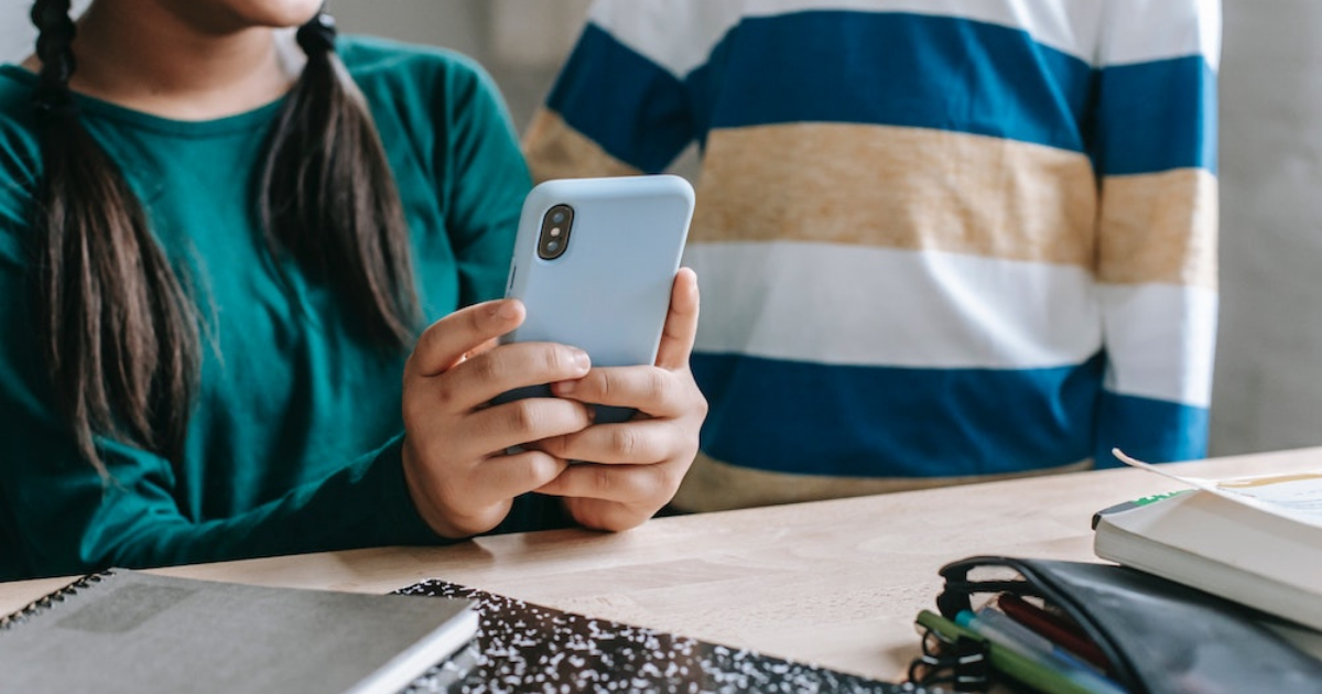 Profile of student looking at phone 