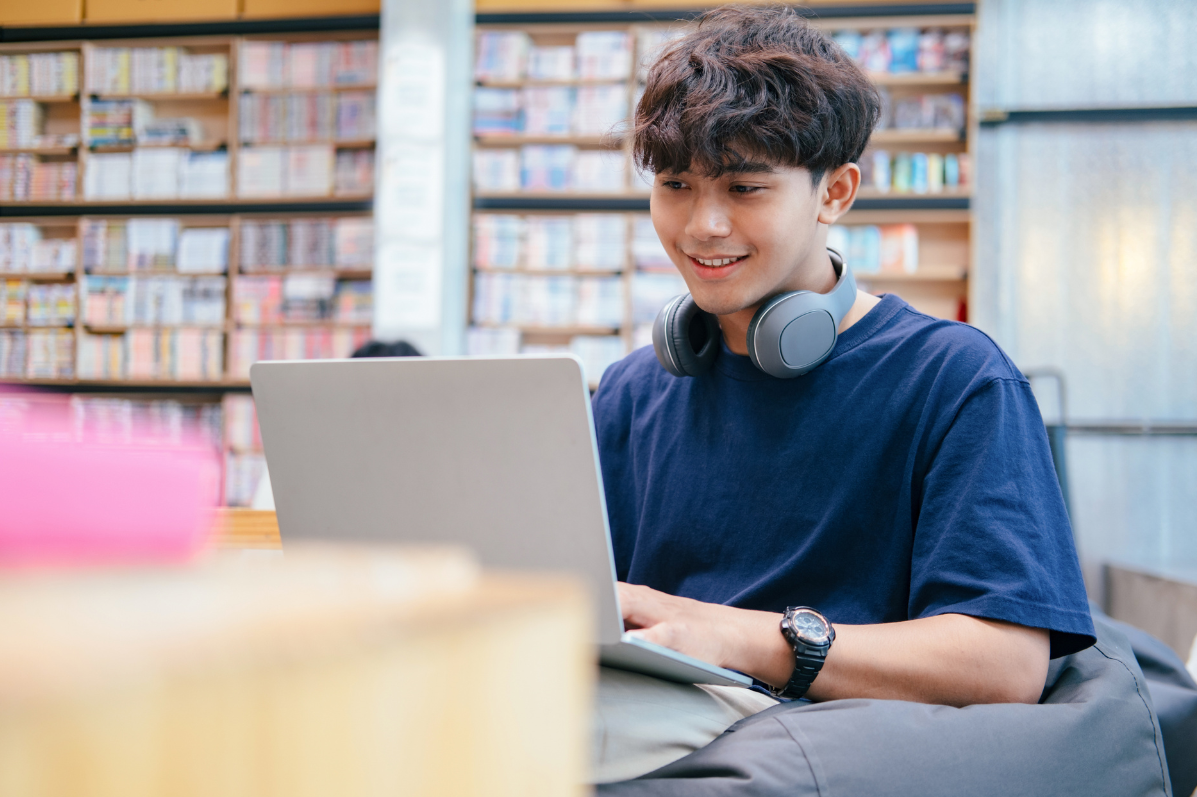 Young student smiling working on their laptop