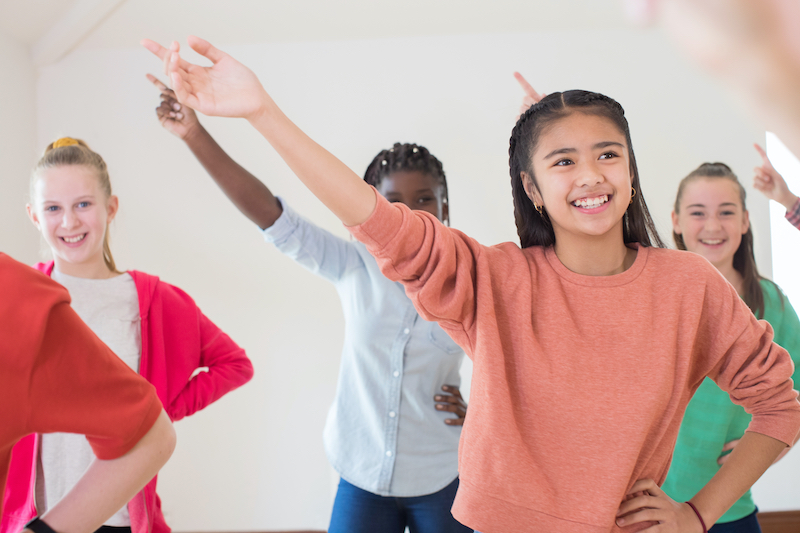 Students performing with their arms in the air