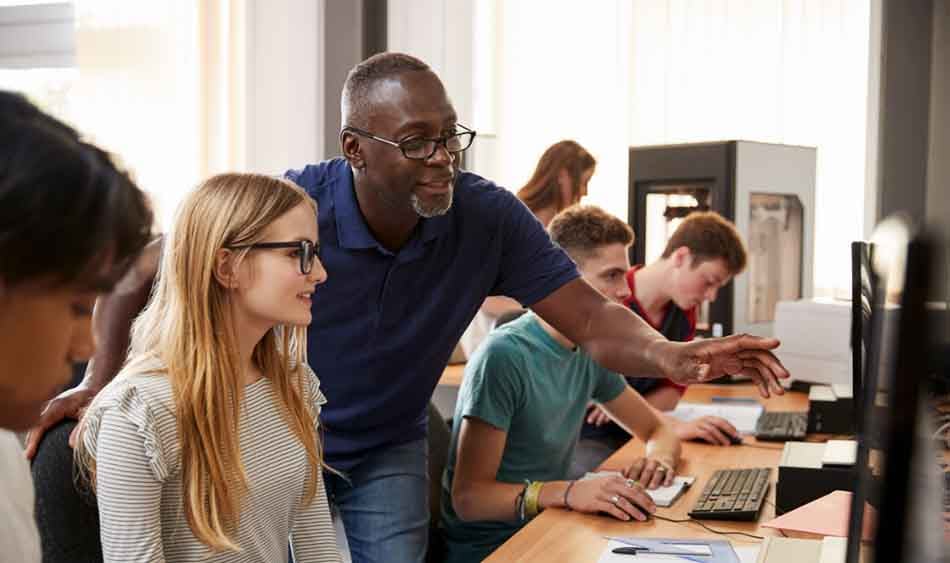 Picture of male teacher pointing to screen of female student 